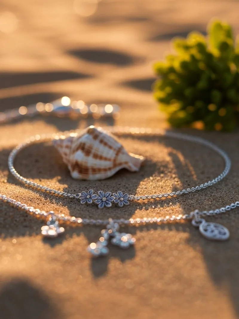 Silver anklets and a shell on sand