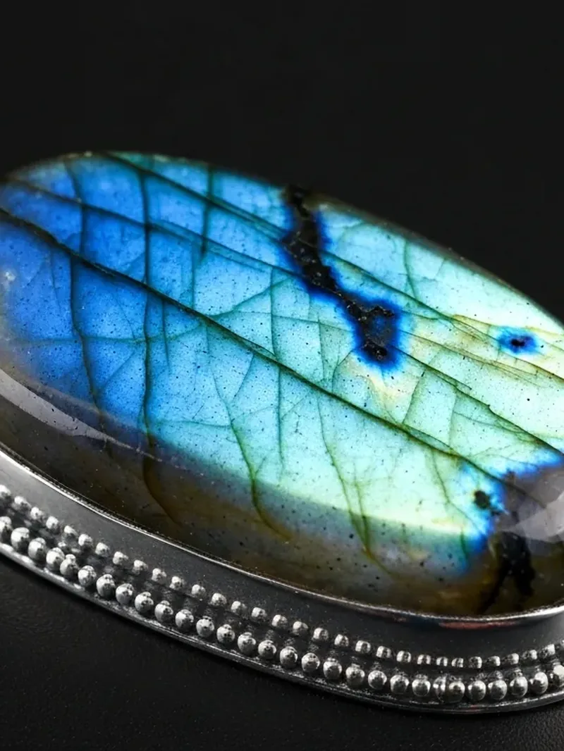 Polished labradorite cabochon in a silver setting